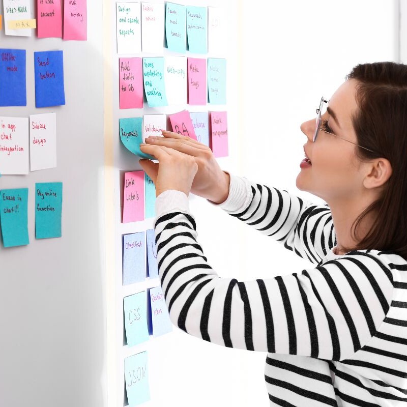 Admin professional arranging sticky notes on a board